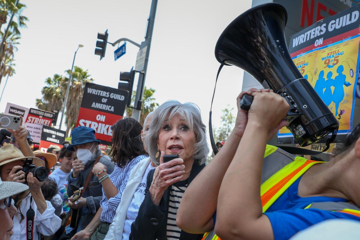 Actress and activist Jane Fonda speaks during a "Striking 9 to 5" picket line in front of Netflix headquarters.
