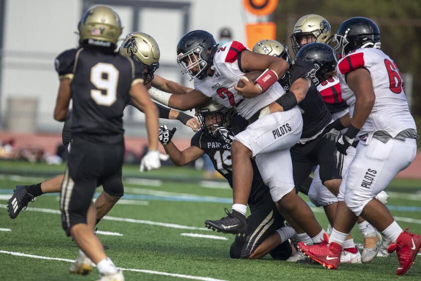 Rolling Hills Estates, CA - September 02: Banning wide receiver/ running back Seth Fao, center, runs as Peninsula High defenders try to stop him in the second half during their win at Peninsula High School in Rolling Hills Estates, Thursday, Sept. 2, 2021. Banning won 38-13. (Allen J. Schaben / Los Angeles Times)