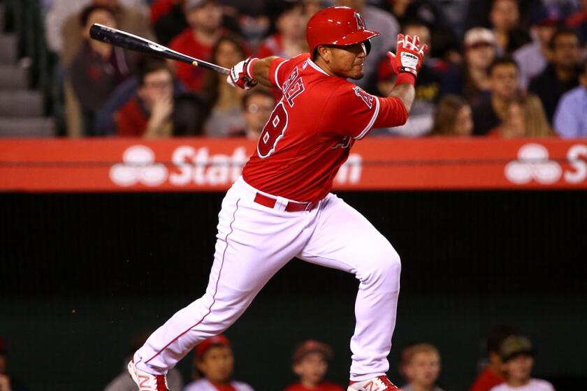 Angels' Carlos Perez hits an RBI single to center in the fourth inning during the Angels' 5-2 win over the Colorado Rockies at Angel Stadium on Tuesday.