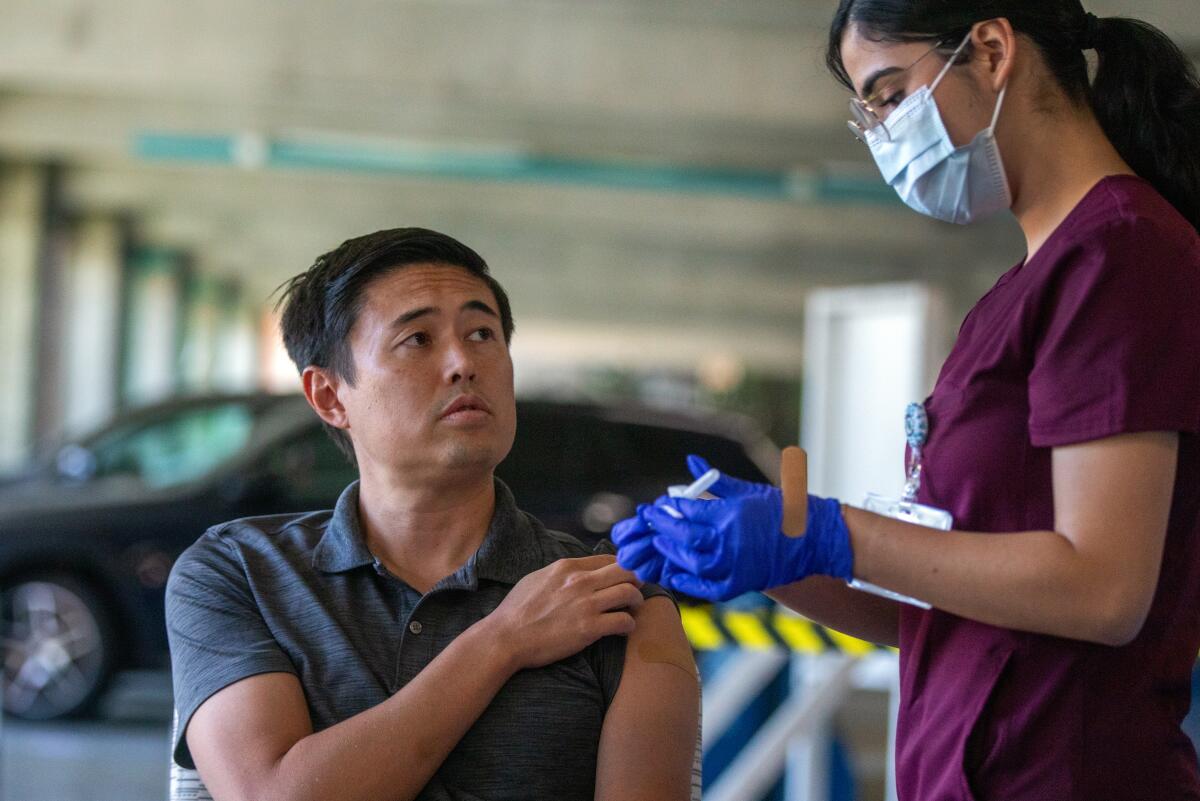 A man prepares to receive a vaccine. 