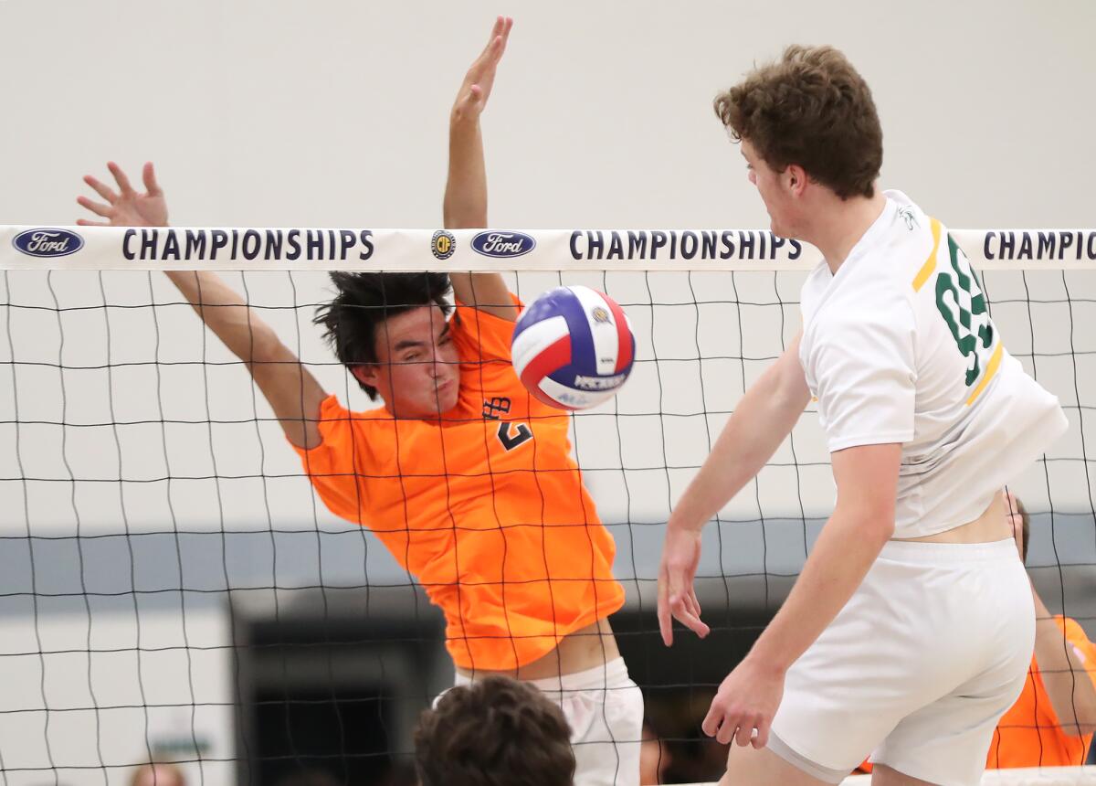 Huntington Beach's Justin Bulsombut (2) blocks a ball from Mira Costa's Alex Heins (99).