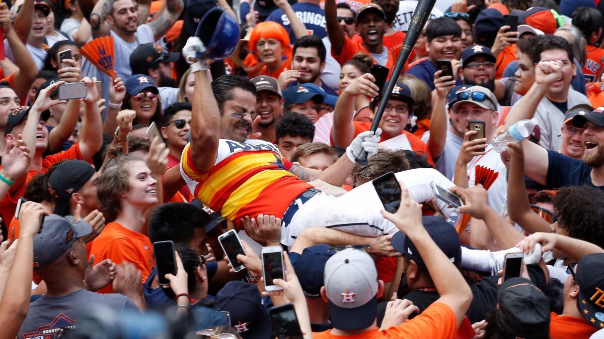 Obed Ceballos body-surfs on the crowd as fans cheer at the Houston Astros' victory parade Friday.