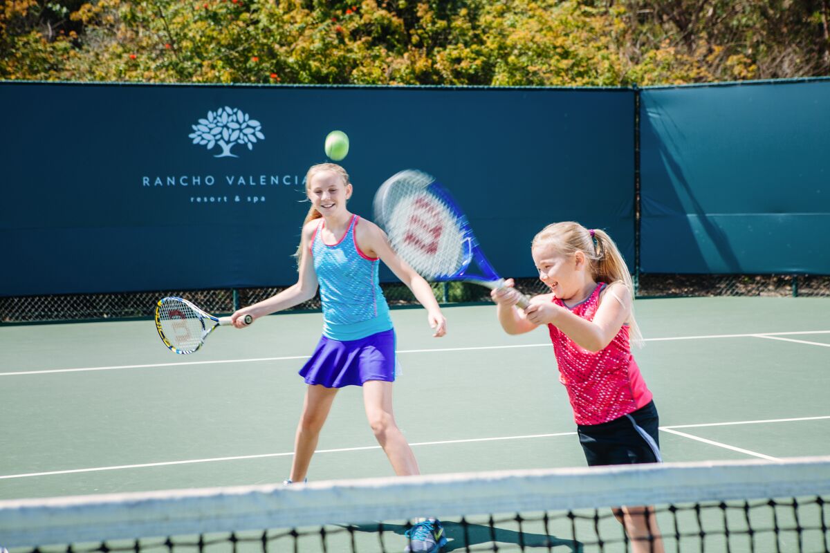 Youth playing tennis at Rancho Valencia Resort & Spa when the courts were open.