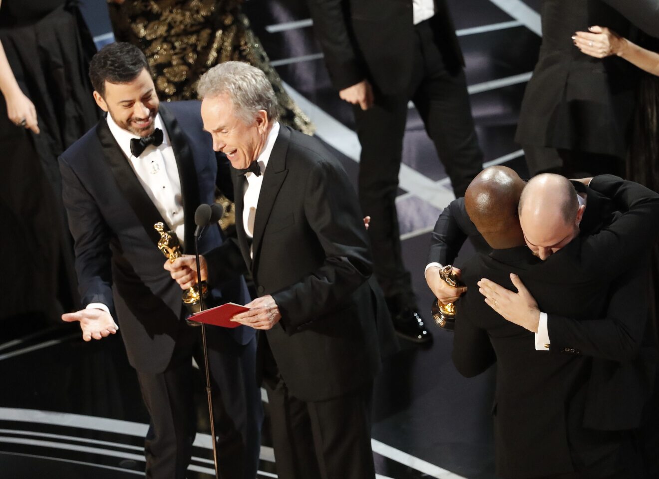 Presenter Warren Beatty and host Jimmy Kimmel try to explain to the audience how the wrong envelope for best picture was read on stage during the Academy Awards telecast on Feb. 26. In background are "Moonlight" writer/director Barry Jenkins, left and "La La Land" producer Jordan Horowitz embracing.