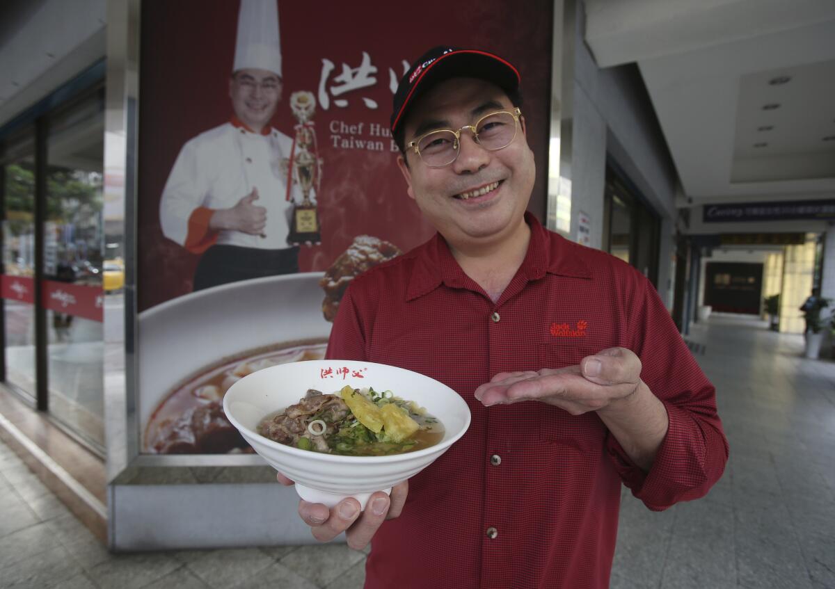 Chef Hung shows pineapple beef noodle outside of his restaurant in Taipei, Taiwan, Wednesday, March 10, 2021. Hung Ching Lung, a Taipei chef, has created a pineapple beef noodle soup at his eponymous restaurant Chef Hung, in what he says is a modest attempt to support Taiwanese pineapple farmers. (AP Photo/Chiang Ying-ying)
