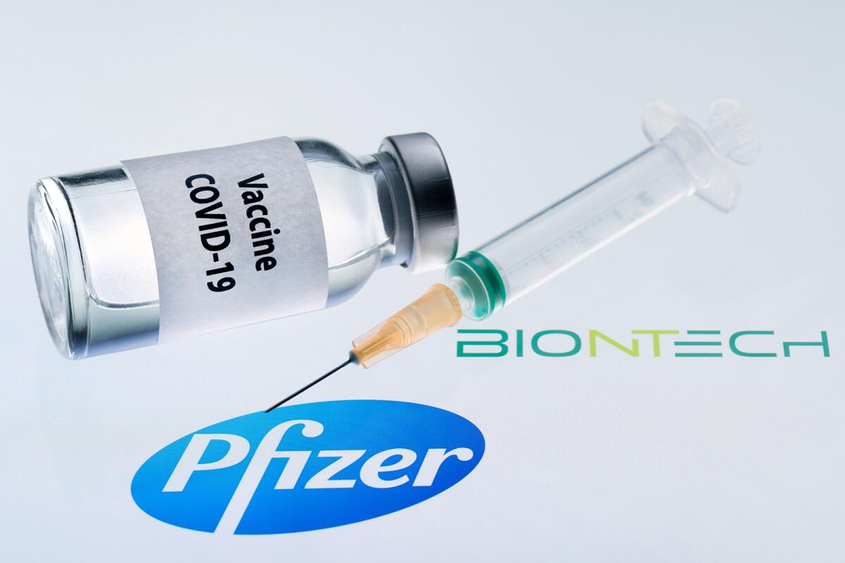 Bottle reading "Vaccine Covid-19" and a syringe next to the Pfizer and Biontech logo.