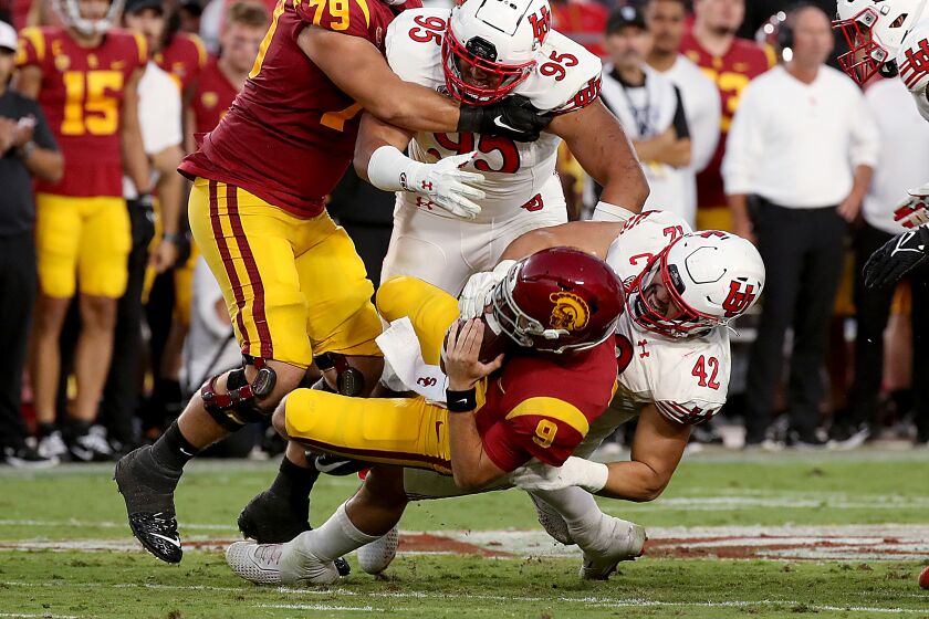 USC quarterback Kedon Slovis gets slammed to the turf by Utah's Mika Tafua 