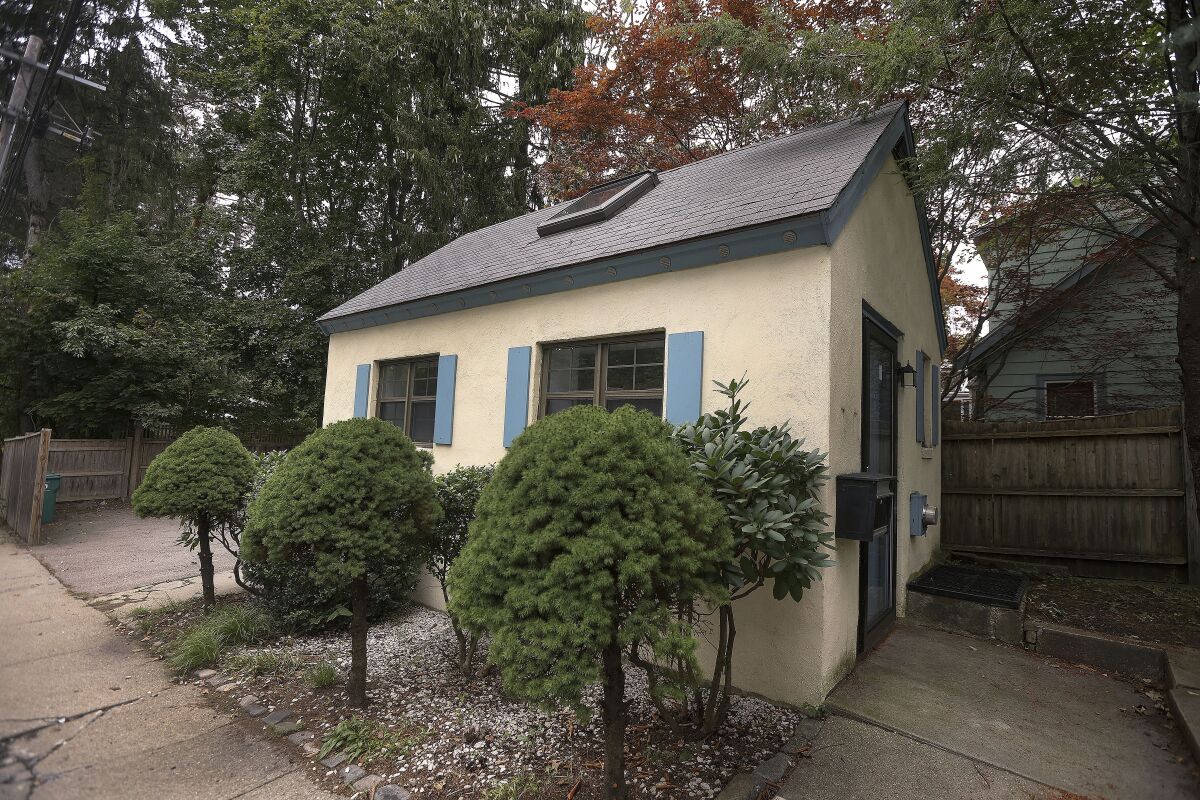 FILE — A tiny home in a wealthy Boston suburb stands next to trees and shrubs Sept. 30, 2021, in Newton, Mass. The house has sold after about a month on the market, albeit for far less than the original asking price almost $450,000. The roughly 250-square-foot (23-square-meter) house sold on Monday for $315,000, according to Coldwell Banker Realty's Hans Brings Results agency. (Barry Chin/The Boston Globe via AP, File)