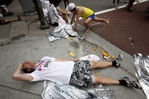 Victor Beyer of Los Angeles lies on the sidewalk after running the Los Angeles Marathon.