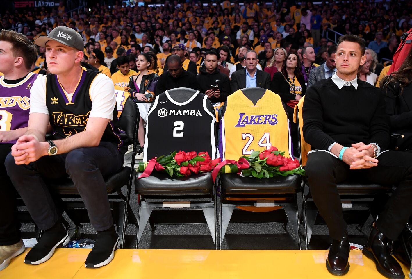 Fans sit next to empty seats held in honor of Kobe Bryant and his daughter Gianna at Staples Center on Jan. 31, 2020.