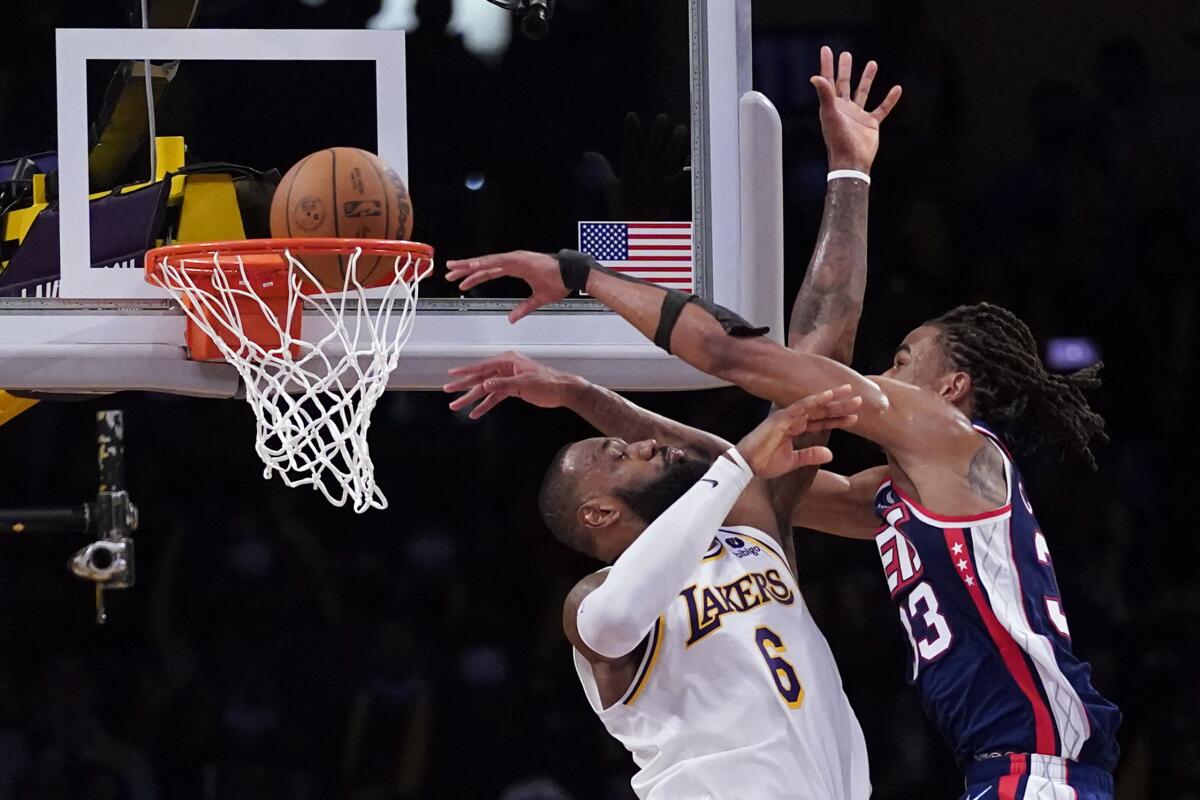 Nic Claxton, de los Nets de Brooklyn, realiza una clavada frente a LeBron James, de los Lakers de Los Ángeles