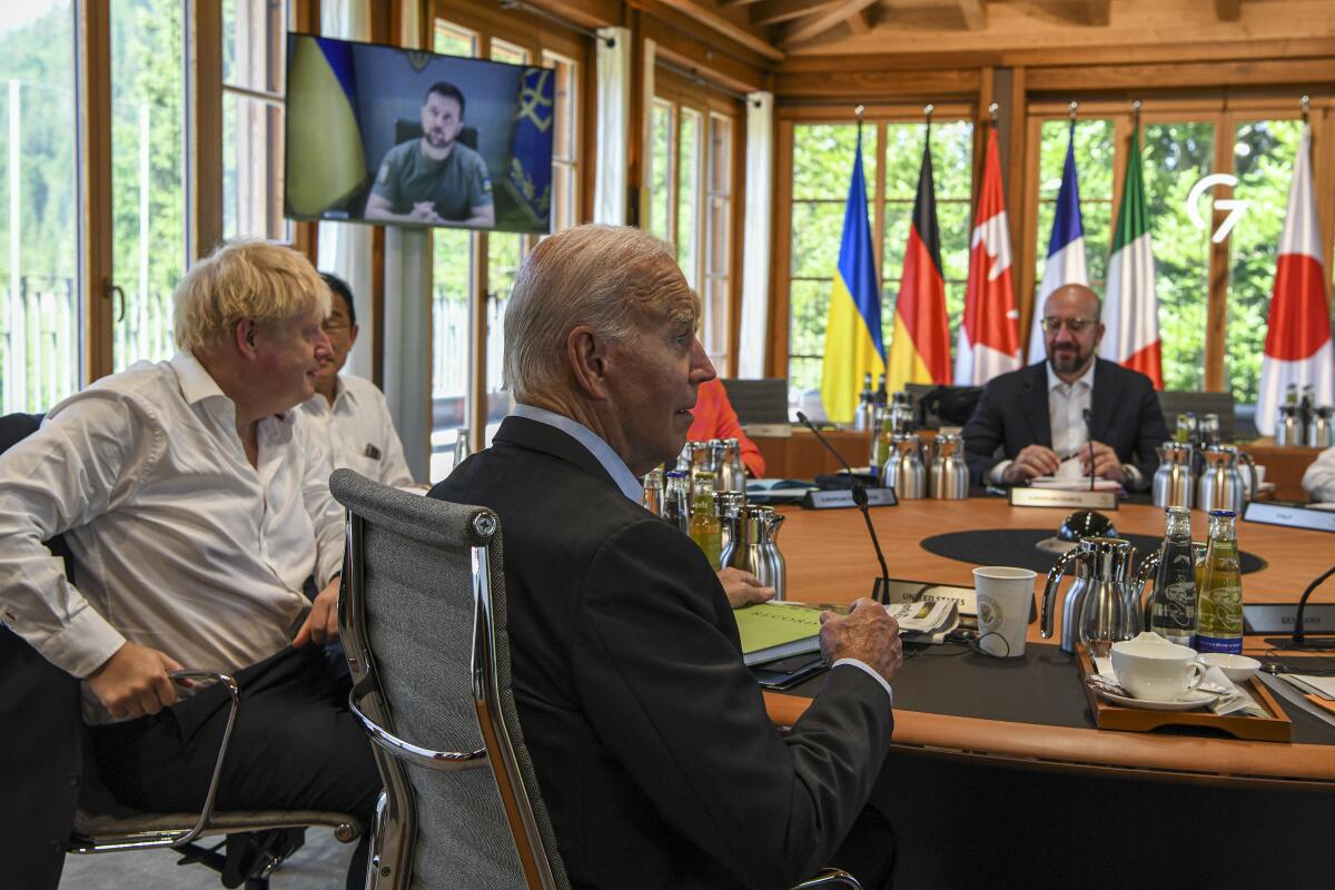 President Biden and other G-7 leaders watch Volodymyr Zelensky on a screen.