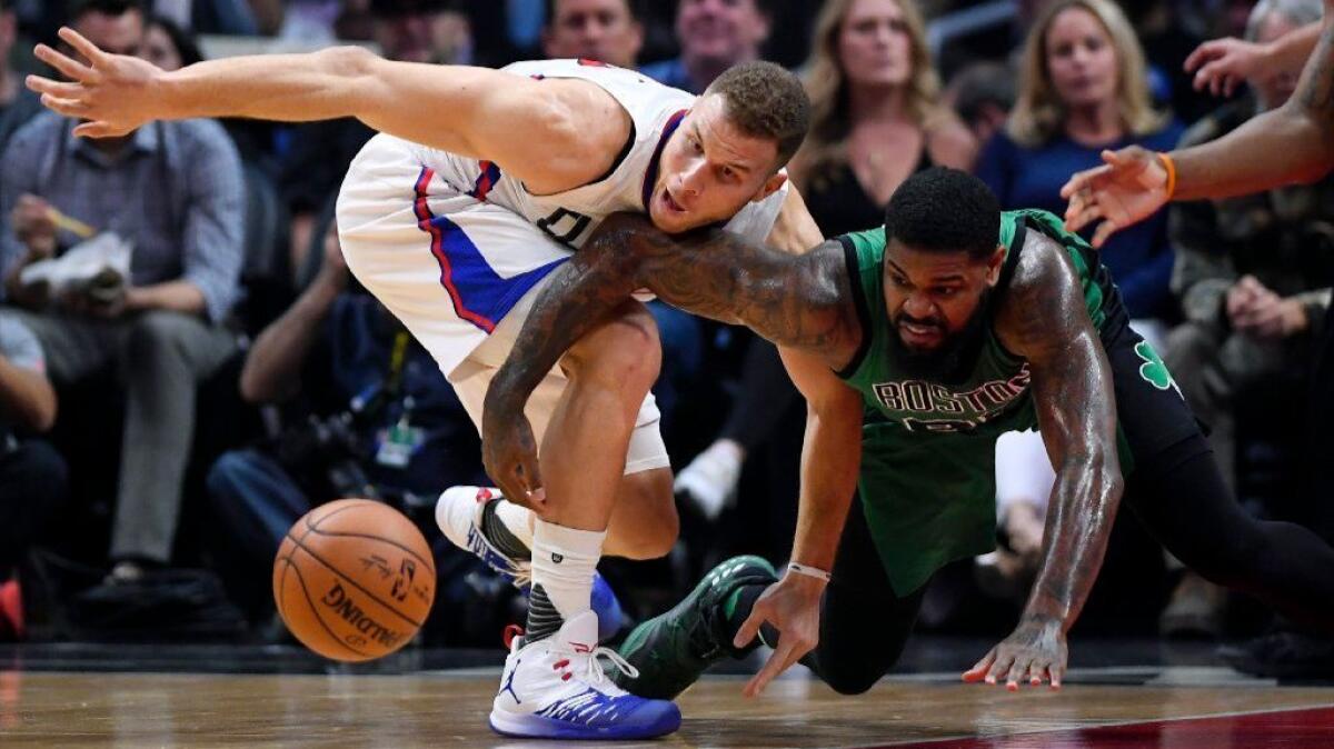 Clippers forward Blake Griffin, left, and Celtics forward Amir Johnson reach for a loose ball during the first half on Monday.