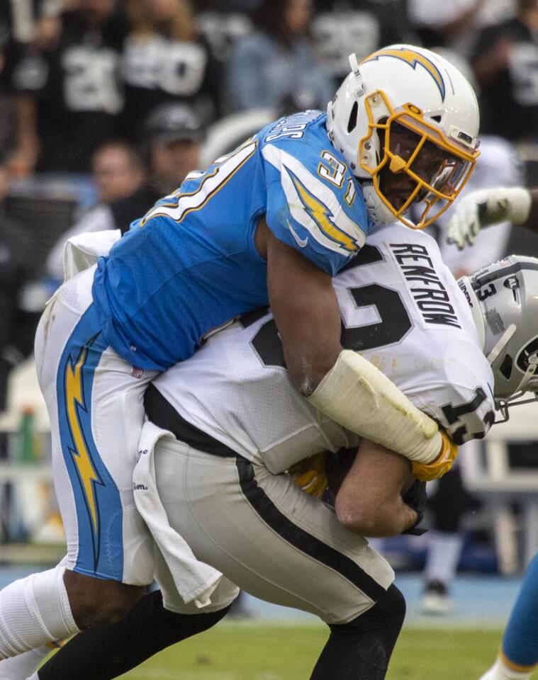 Chargers defensive back Adrian Phillips tries to bring down Oakland Raiders wide receiver Hunter Renfrow.