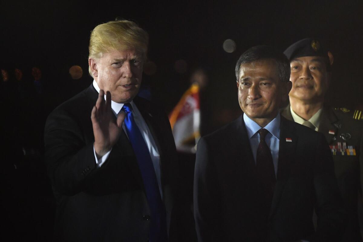 President Trump is met by Singapore's foreign minister, Vivian Balakrishnan.