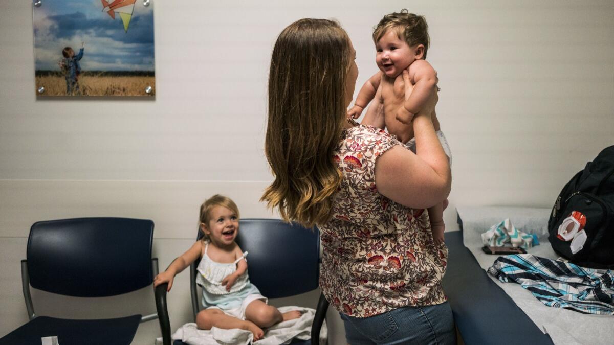 Kara Coltrin, 24, holds up her 6-month-old son, Maverick, during a medical appointment at Rady Children's Hospital-San Diego earlier this month.