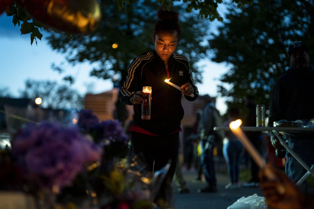 Alexis Rodriguez lights candles at a memorial.