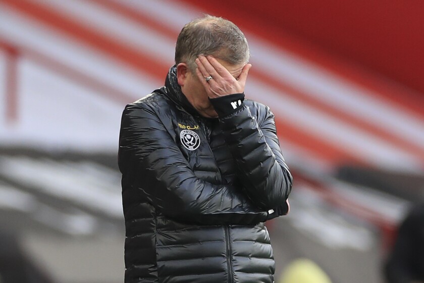 Sheffield United's manager Chris Wilder covers his face during an English Premier League soccer match between Sheffield United and Southampton at the Bramall Lane stadium in Sheffield, England, Saturday March 6, 2021. (Mike Egerton/Pool via AP)