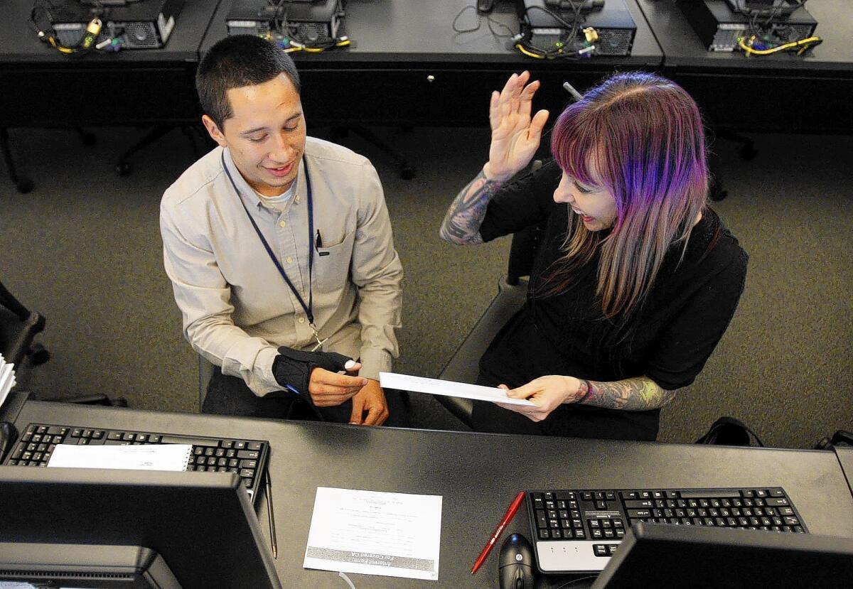 Stephanie MacDougall receives information about Covered California from Fabrizzio Perez at Los Angeles Trade Technical College.