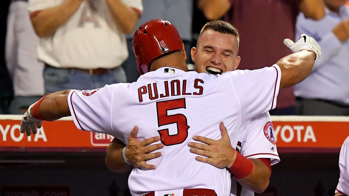 Mike Trout, right, congratulates Albert Pujols, who hit a home run against Cincinnati last Aug. 29.