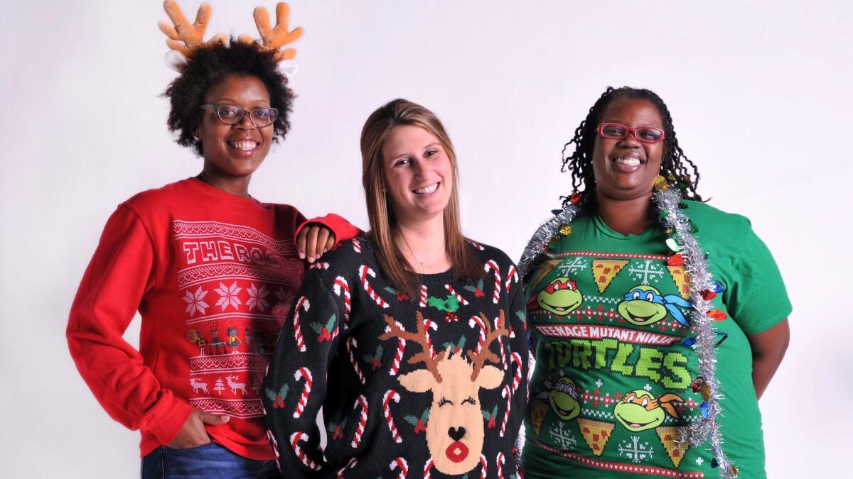 Alaska Airlines is letting passengers wearing ugly Christmas sweaters board early Dec. 15. From left, Dia Hancock of Mitchellville, Jennifer Eisenberg of Baltimore, and Keisha Jones of Mitchellville, Md., show off their "ugly" Christmas sweaters.