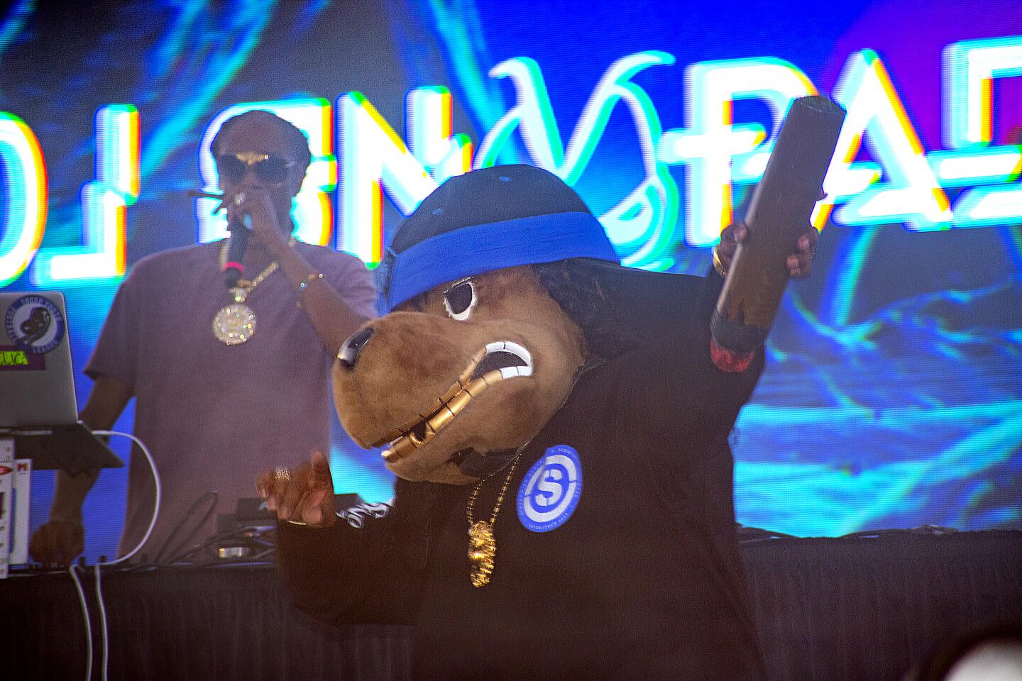 Snoop Dogg, left, performing as DJ Snoopadelic, takes the stage at Sunday's Nood Beach festival at SeaLegs by the Beach in Huntington Beach.