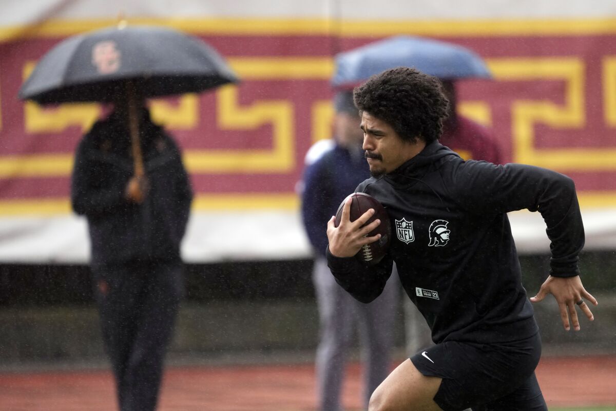 USC geri koşuyor Travis Dye Salı günü okulun NFL profesyonel gününde yağmurda koşuyor.
