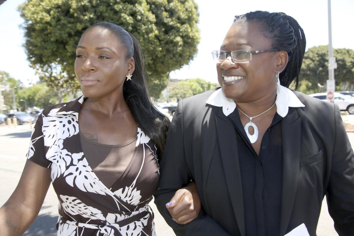 Maisha Allums, left, daughter of Marlene Pinnock, the woman punched by a CHP officer, with attorney Caree Harper before a news conference on Pinnock's lawsuit.