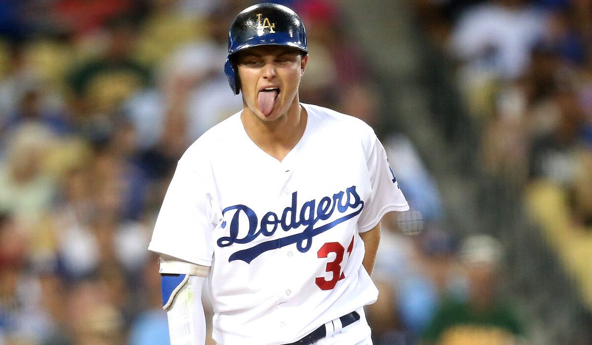 The Dodgers' Joc Pederson sticks out his tongue as he reacts to fouling a ball off his foot in the fourth inning against the Oakland Athletics on July 28.