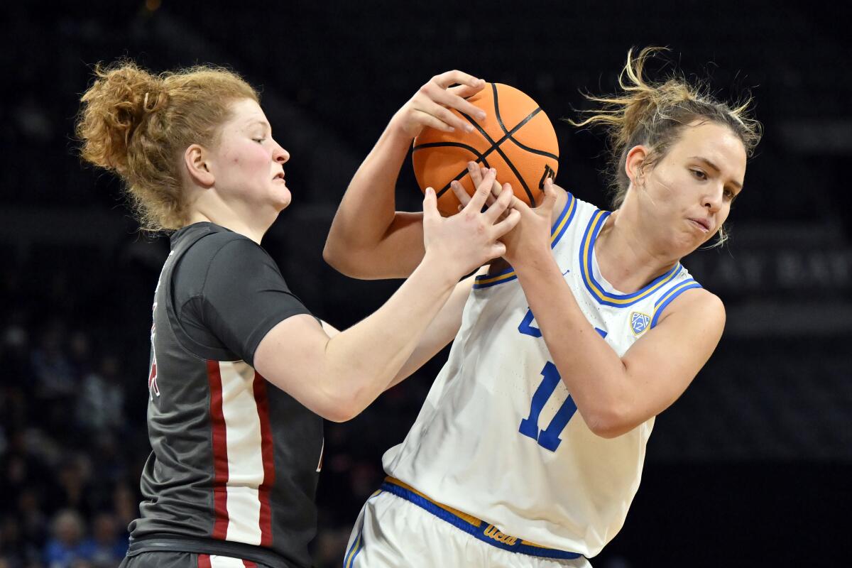 Washington State center Jessica Clarke and UCLA forward Emily Bessoir battle for the ball.