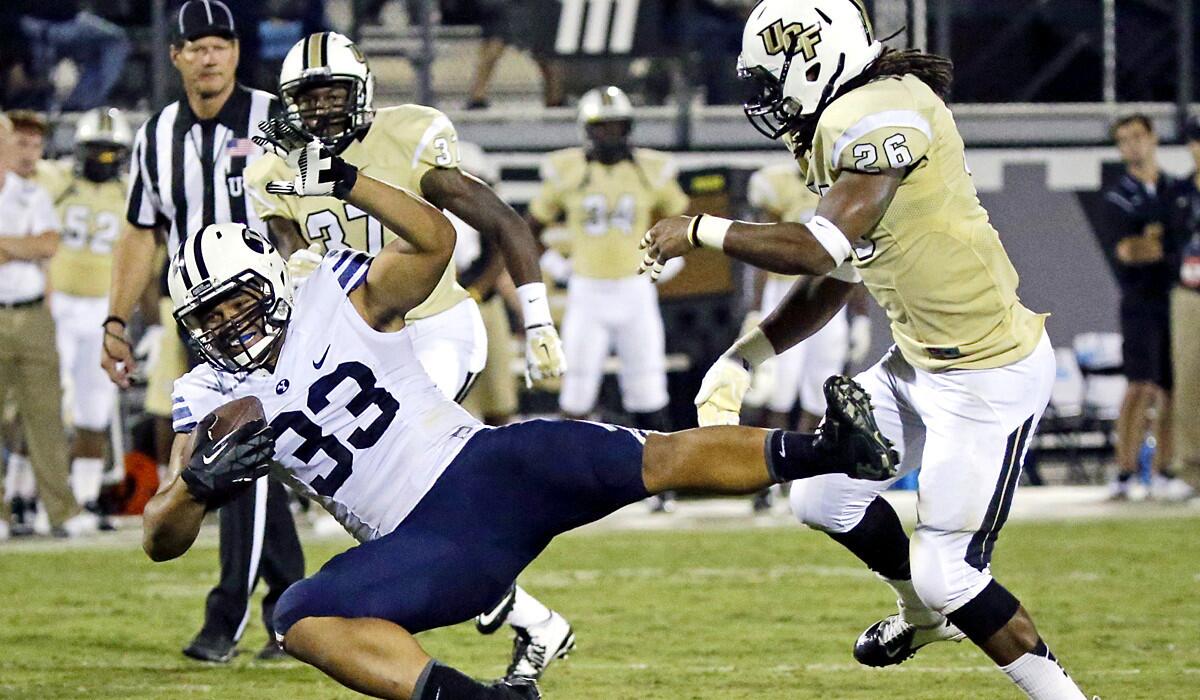 Brigham Young running back Paul Lasike (33) is brought down by Central Florida defensive back Clayton Geathers (26) after a reception in the first half Thursday night.