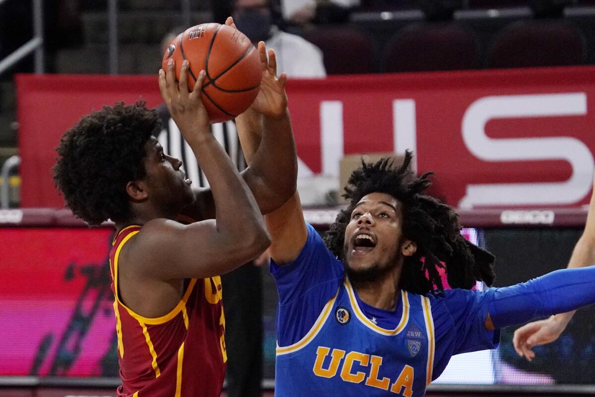 USC's Ethan Anderson shoots while UCLA's Tyger Campbell defends Feb. 6 at Galen Center.