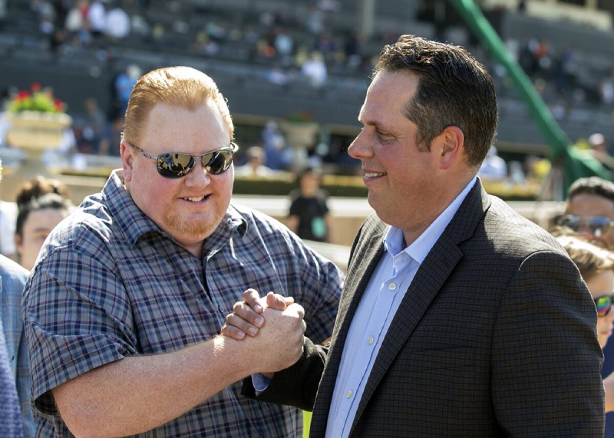 Trainer Philip D'Amato (right) celebrates Going Global's win at Santa Anita with co-owner Michael Nentwig. 
