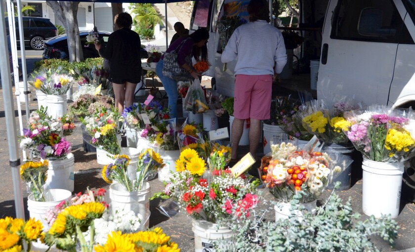 Customers flock to David Franco's flower stand at the Corona del Mar Farmer's Market.