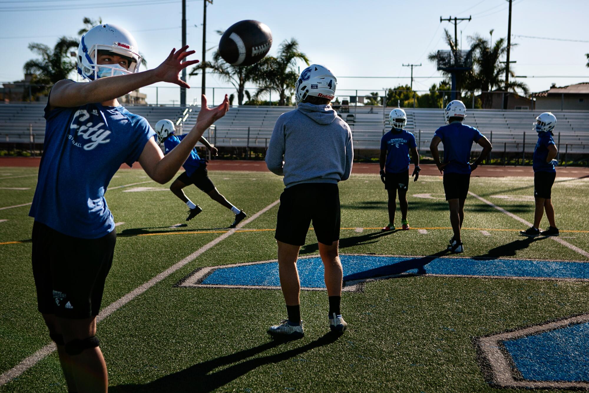 Quarterbacks and receivers at Culver City High School work on drills its first official football practice.