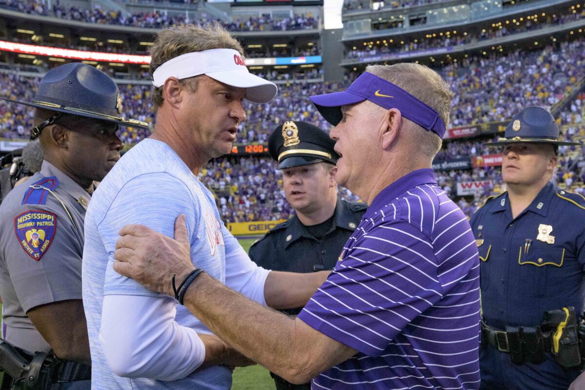 LSU coach Brian Kelly shakes hands with Mississippi coach Lane Kiffin