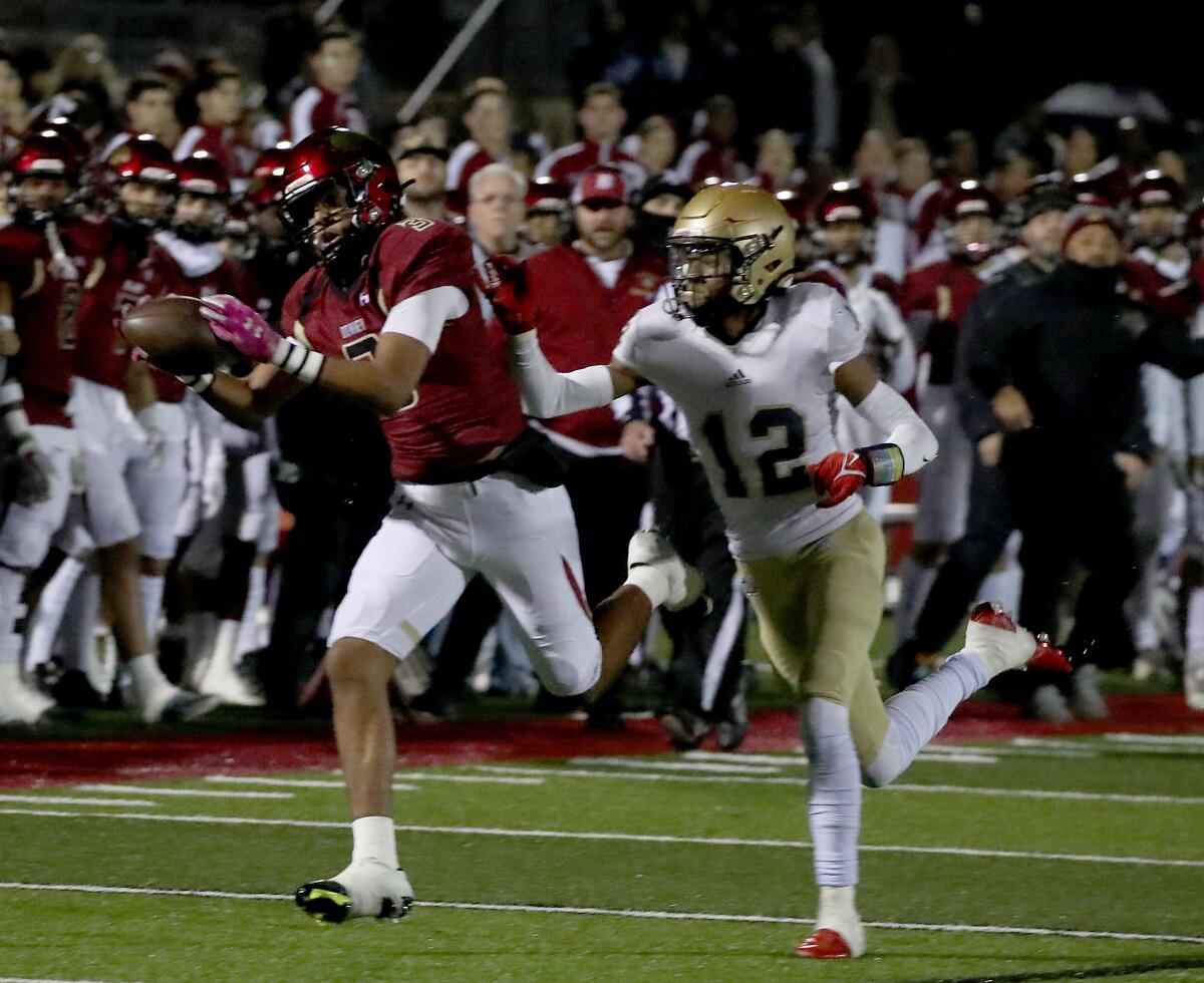 Downey receiver Byrant Carey catches a pass en route to the end zone against Chula Vista Mater Dei defensive back Evan Isidro