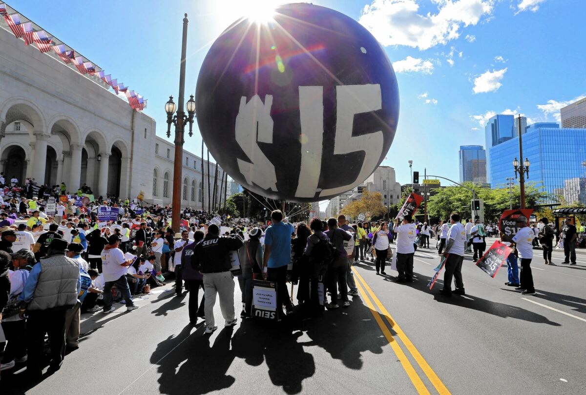 Protesters call for a higher minimum wage in Los Angeles in November. The wage will rise in California, New York and several other states on Friday.