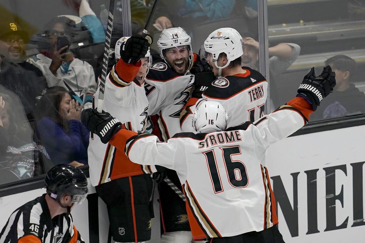 Ducks forward Adam Henrique, center, is congratulated by teammates.