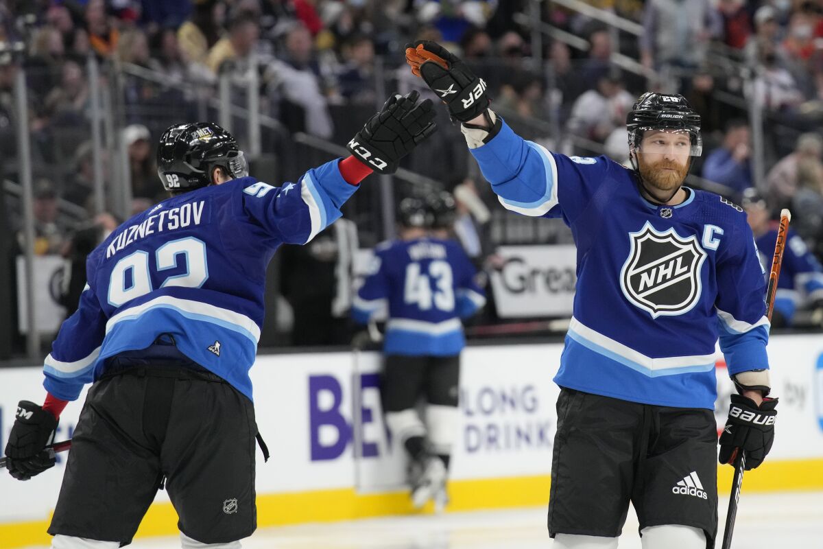 The Metropolitan Division's Evgeny Kuznetsov, left, and Claude Giroux celebrate during the NHL All-Star game Feb. 5, 2022.