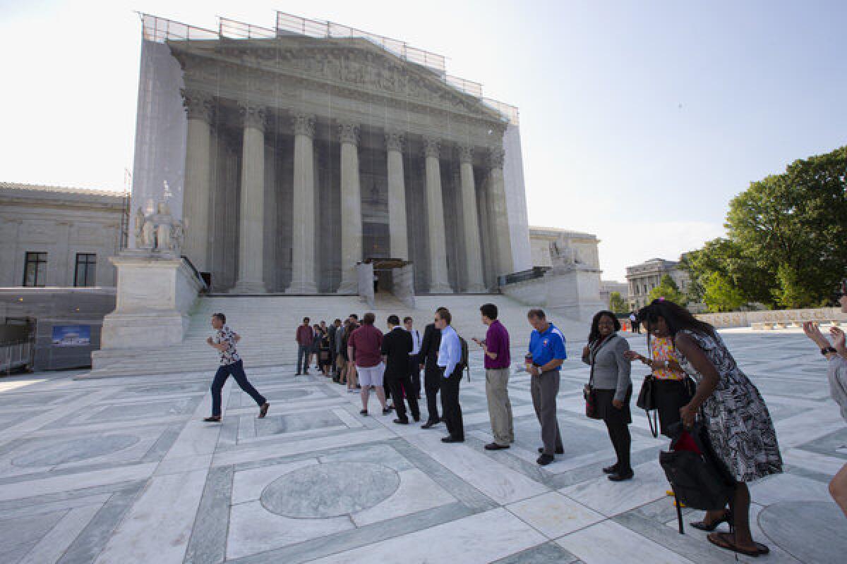 Visitors wait outside the Supreme Court in Washington on Thursday.