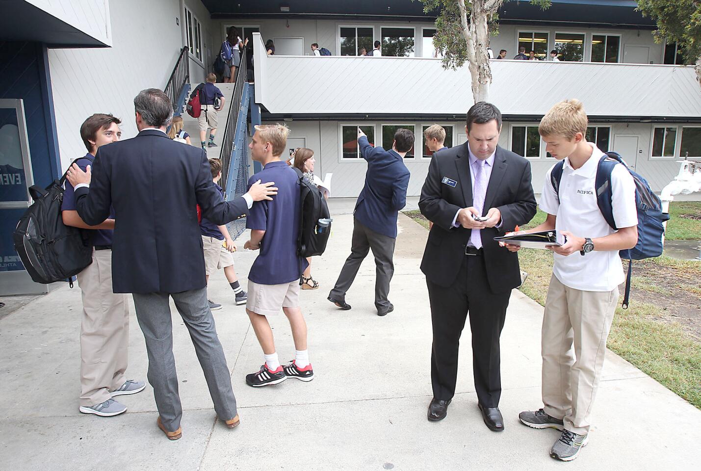 Head of School David O'Neil, left, and languages teacher Mike Arldt, right, help students navigate on the first day of school at Pacifica Christian High School in Newport Beach on Tuesday morning.