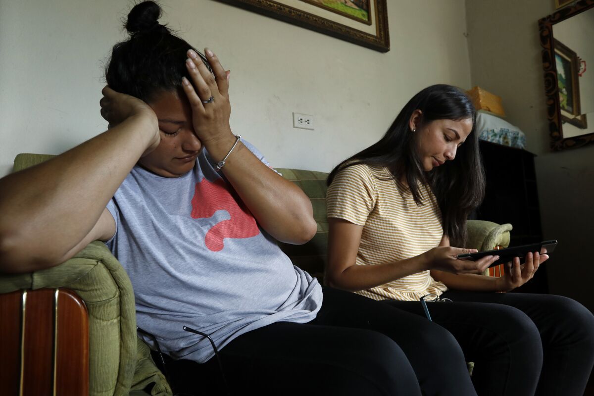 Glenda Reyes, 33, left, and her sister, Angelica Reyes, 24, mourn the death of their brother, Henry Diaz Reyes. "He had so many plans, and they took them," said Glenda. (Carolyn Cole / Los Angeles Times)