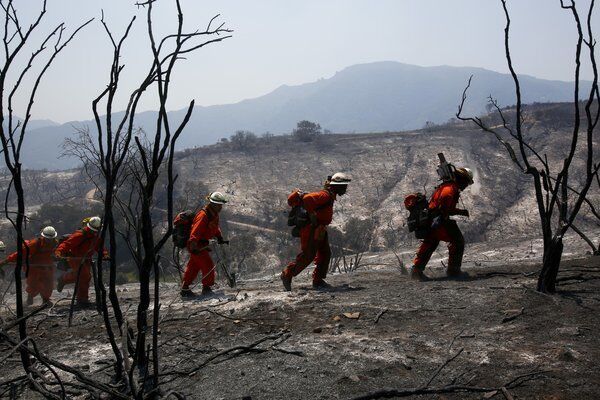 A fire crew made up of prison inmates climbs through a burned area in Hidden Valley looking for hot spots.