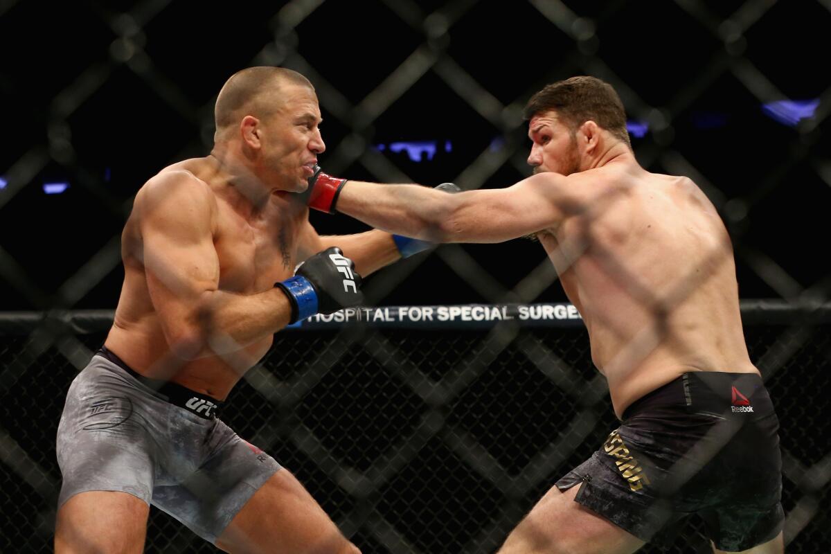 Georges St-Pierre, left, and Michael Bisping trade blows during their middleweight championship bout at UFC 217.