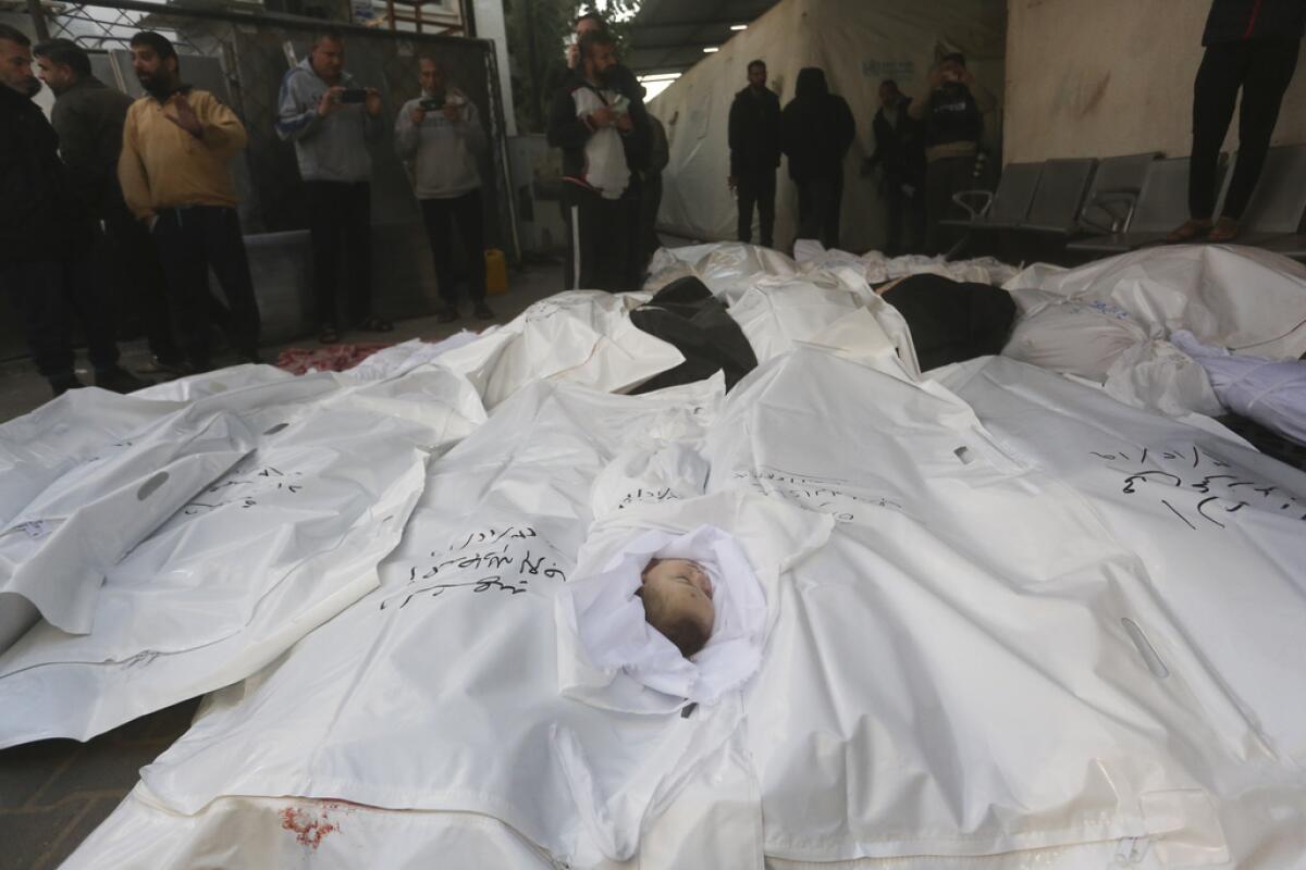 Palestinos junto a los cuerpos de sus familiares que murieron