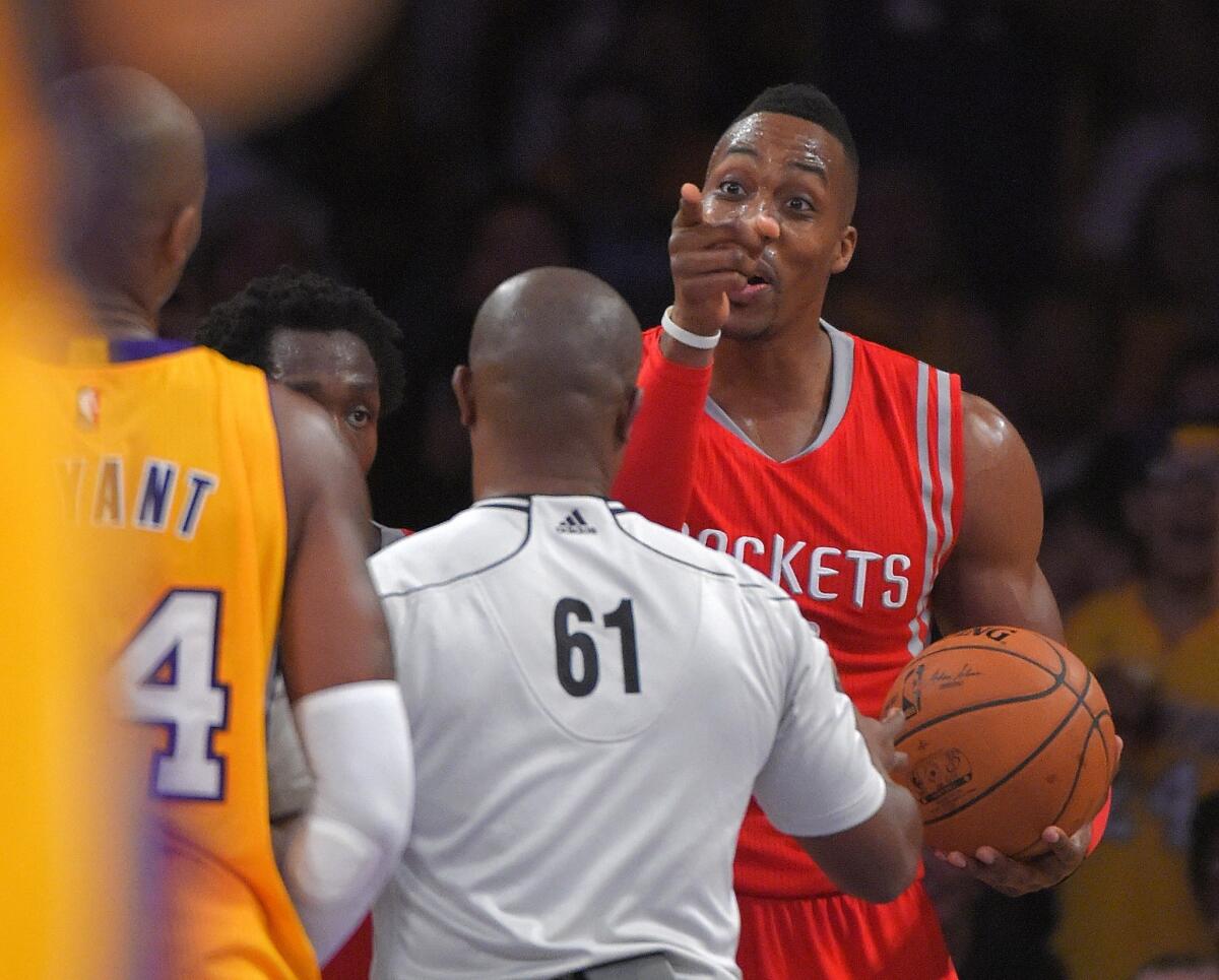 Kobe Bryant and Dwight Howard exchange words during the Lakers' season-opening loss to the Houston Rockets, 108-90.