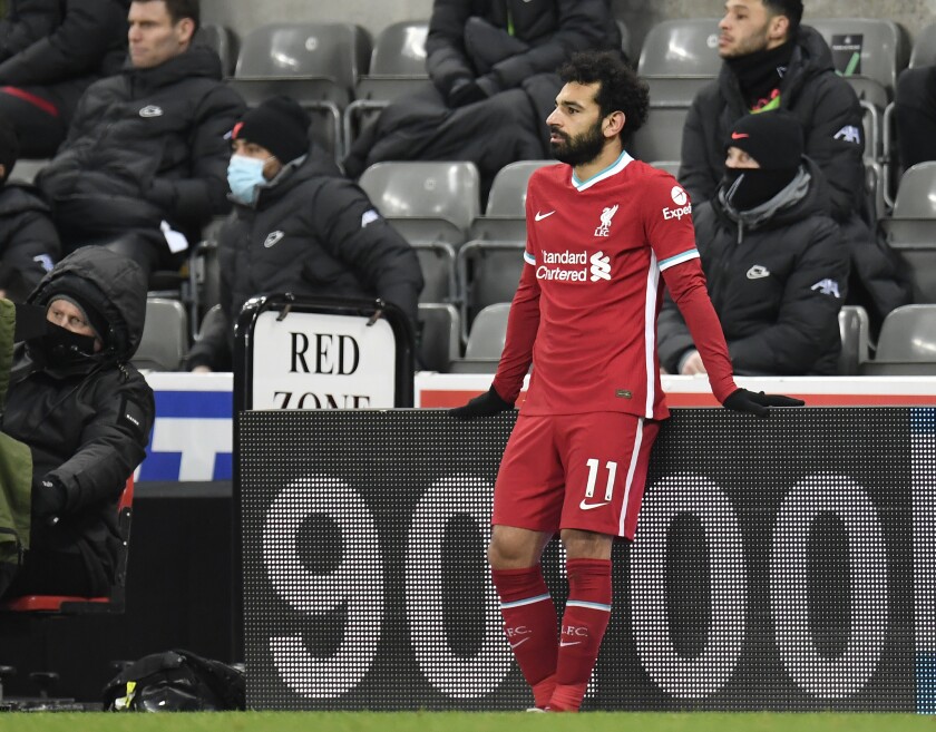 Liverpool's Mohamed Salah rests on a side board after being substituted during the English Premier League soccer match between Newcastle United and Liverpool at St James' Park stadium in Newcastle, England, Wednesday, Dec. 30, 2020. (Peter Powell/ Pool via AP)