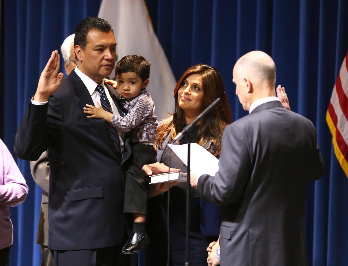 Alex Padilla holds his son Alejandro as he is sworn in as secretary of state by Gov. Jerry Brown on Jan. 5, 2015. Among the challenges Padilla faces is boosting low voter turnout across California.