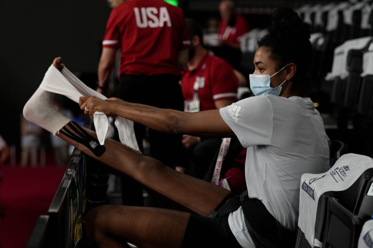 United States' Jordan Thompson treats her injured foot during the women's volleyball preliminary round pool B match between United States and Italy at the 2020 Summer Olympics, Monday, Aug. 2, 2021, in Tokyo, Japan. (AP Photo/Frank Augstein)